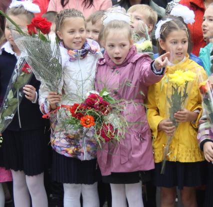 Две девочки с букетами цветов в руках