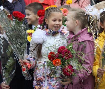 Две девочки держат в руках цветы