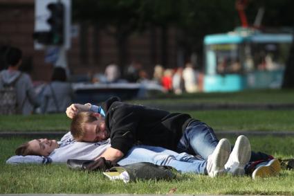 Парень с девушкой лежат на траве