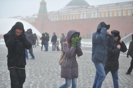 Красная площадь. На снимке: люди закрывают лицо руками, защищаясь от метели.