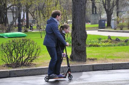 Парк Горького. На снимке: мужчина с ребенком на самокате.