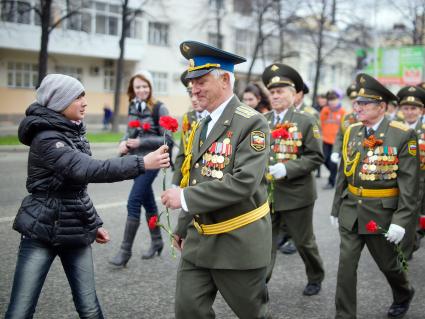 Празднование Дня Победы в Екатеринбурге. На снимке: подросток дарит цветы ветерану.