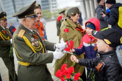 Празднование Дня Победы в Екатеринбурге. На снимке: дети дарят ветерану цветы.