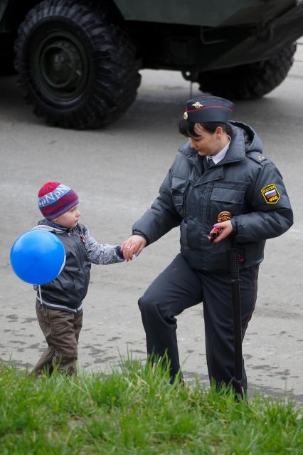 Празднование Дня Победы в Екатеринбурге. На снимке: Женщина полицейский и ребенок с надувным шариком.