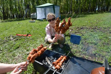 Отдых на природе. На снимке: приготовление свиного шашлыка.