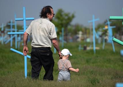 Мужчина с ребенком на кладбище.