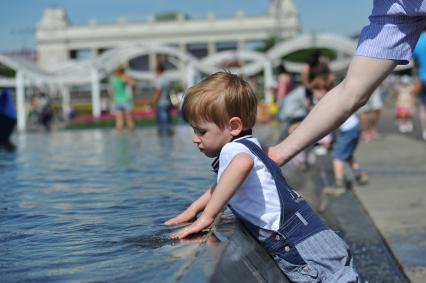 Парк Горького. На снимке: мальчик трогает руками воду в фонтане.