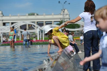 Парк Горького. На снимке: девочка трогает руками воду в фонтане.