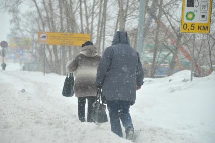 Снегопад в городе. На снимке: пешеходы на заснеженной улице.