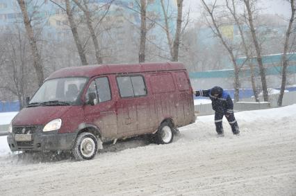 Снегопад в городе. На снимке: застрявший микроавтобус на заснеженной дороге.