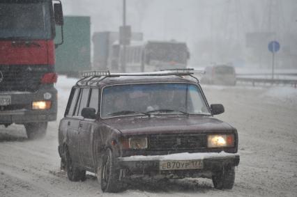 Снегопад в городе. На снимке: автомобиль `Жигули` на шоссе.