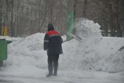 Последствия снегопада. На снимке: дворник с лопатой.