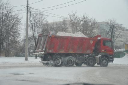 Последствия снегопада. На снимке: вывоз снега на грузовом автомобиле.