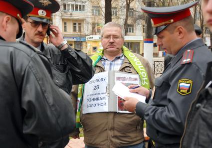 Полицейские проверяют документы у мужчины из партии `Яблоко`, требующего свободы `узникам болотной`.