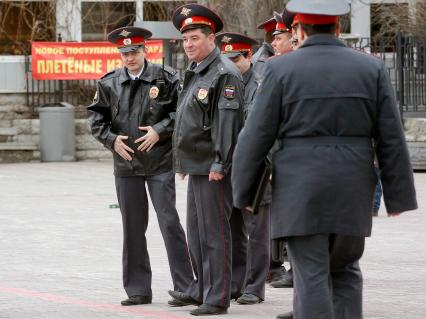 Празднование 1 мая в Екатеринбурге. На снимке: полицейские на фоне плаката `Новое поступление. Плетеные`.