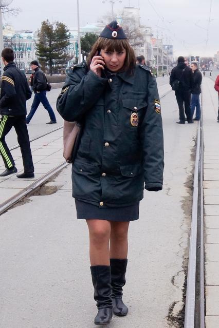Празднование 1 мая в Екатеринбурге. На снимке: женщина полицейский разговаривает по мобильному телефону.