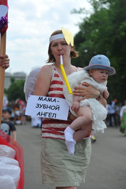 Международный день защиты детей. `Парад колясок` в ЦПКиО имени Горького. На снимке: женщина с ребенком на руках