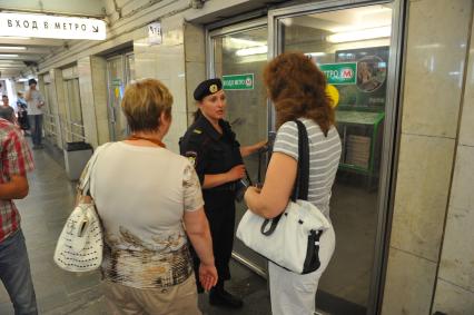 Задымление на Сокольнической ветке московского метро. На снимке: сотрудница полиции у входа на станцию метро `Охотный Ряд`, закрытую на вход.