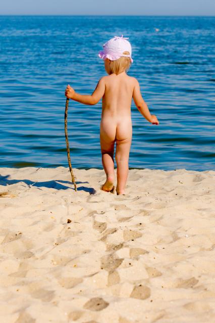 Ребенок идет по пляжу.