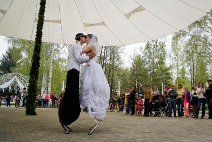 Молодожены Екатерина и Максим Березины из Екатеринбурга на церемонии бракосочетания, под свадебные наряды ребята надели `джоли-джампинг` - ходули с пружинами.