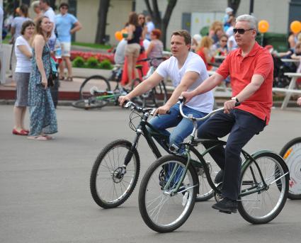 Открытие велопроката в Парке Горького. На снимке: руководитель Департамента транспорта и развития дорожно-транспортной инфраструктуры Москва Максим Ликсутов (слева) и мэр Москвы Сергей Собянин (в центре) едут на велосипедах.