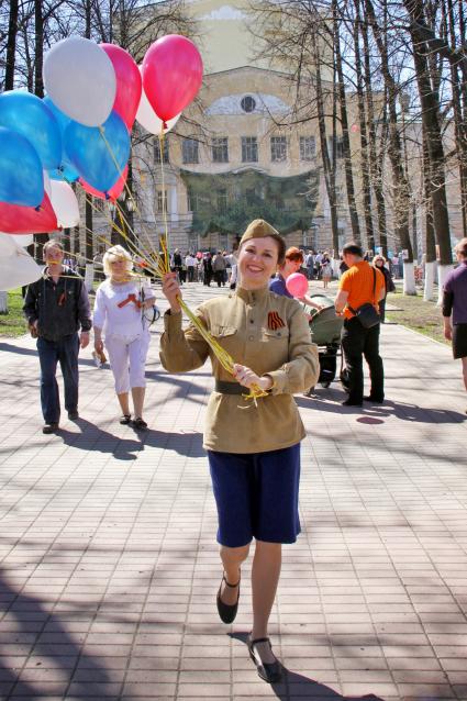 Празднование Дня Победы в Ярославле. Женщина в гимнастерке с надувными шариками в руках.