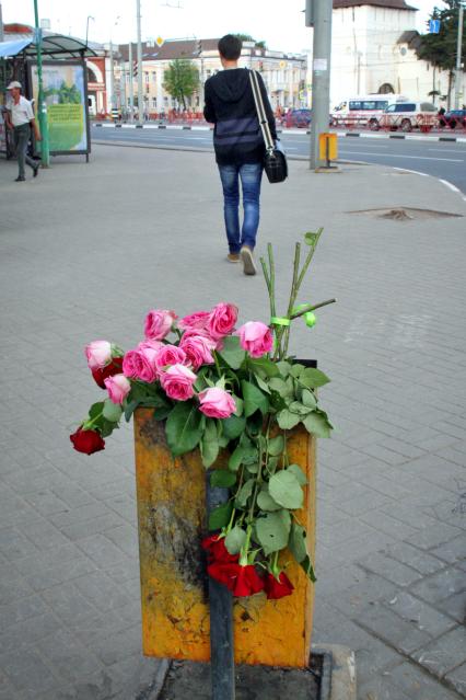 Выброшенные цветы в уличную урну.