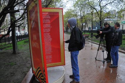 Рождественский бульвар . Инсталляция со стихами о войне ко Дню Победы. На снимке: прохожий  у стенда со стихами