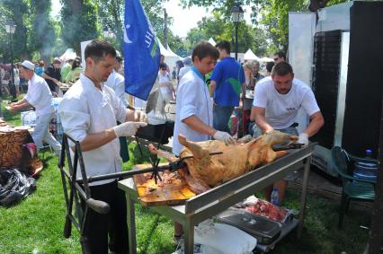 Второй Фестиваль мировой еды и путешествий `Вокруг света` в саду `Эрмитаж`. На снимке: приготовление барана на вертеле.