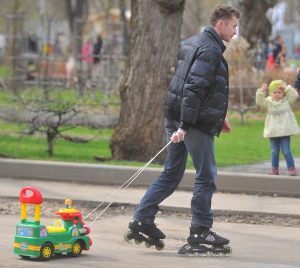 Центральный Парк Культуры и Отдыха имени Горького. На снимке: мужчина на роликах катит за собой детскую машинку.