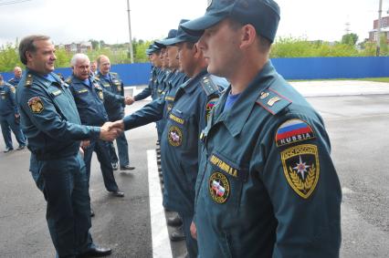Визит главы МЧС РФ Владимира Пучкова в Иркутск. Пучков посетит церемонию прощания с сотрудниками МЧС РФ, погибшими при крушении вертолёта МИ-8 6 мая 2013 г. На снимке: Владимир Пучков (слева) и начальник Сибирского регионального центра МЧС РФ Владимир Светельский (в центре) приветствует сотрудников пожарной части №1.