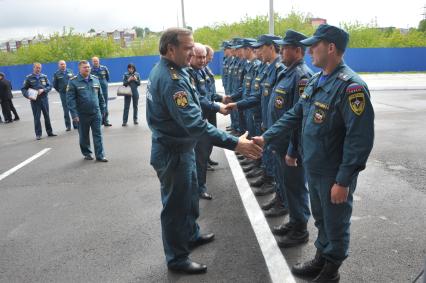 Визит главы МЧС РФ Владимира Пучкова в Иркутск. Пучков посетит церемонию прощания с сотрудниками МЧС РФ, погибшими  при крушении вертолёта МИ-8 6 мая 2013 г. На снимке: Владимир Пучков (слева) и начальник Сибирского регионального центра МЧС РФ Владимир Светельский  (в центре) приветствует сотрудников пожарной части №1.