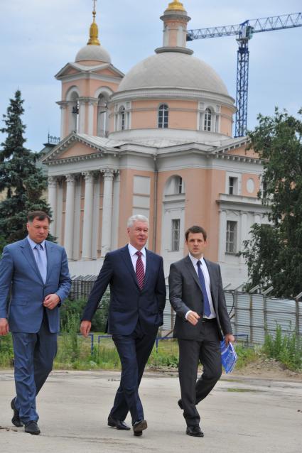 Врио Мэра Москвы Сергей Собянин (в центре) и главный архитектор Москвы Сергей Кузнецов (справа) во время посещения территории Зарядья в Москве.