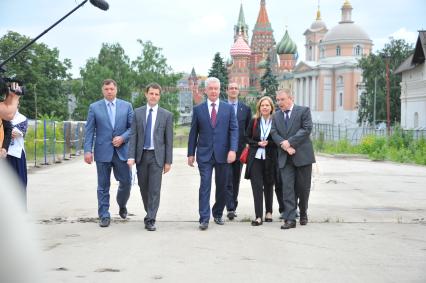 Заместитель мэра Москвы по вопросам градостроительной политики и строительства Марат Хуснуллин, врио Мэра Москвы Сергей Собянин (в центре), декан по внешним связям в Школе архитектуре и дизайна IE Марта Торн (третья справа), ландшафтный архитектор Кен Смит (второй справа) во время посещения территории Зарядья в Москве.