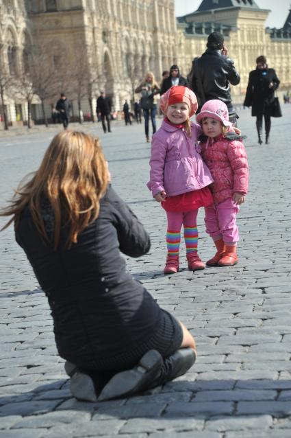 Женщина фотографирует детей.