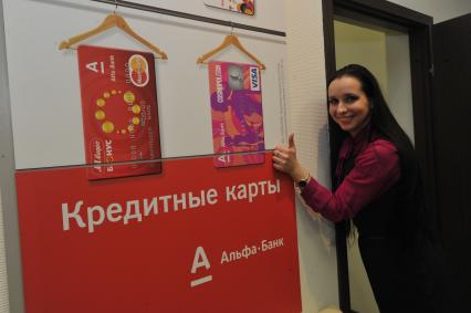 Отделение `Альфа-банка`. На снимке: сотрудница банка рекламирует ассортимент банковских кредитных карт.