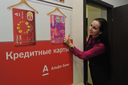 Отделение `Альфа-банка`. На снимке: сотрудница банка рекламирует ассортимент банковских кредитных карт.