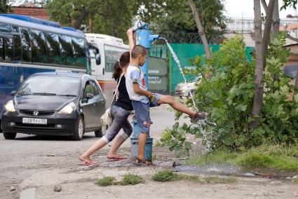 Жара. Дети балуются с водонапорной колонкой.