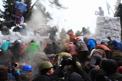 Празднование Масленицы. Празднование Масленицы. Толпа народа ломает снежную стену.