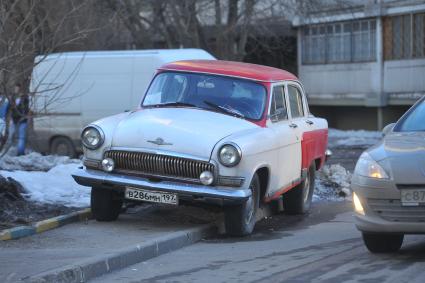 Припаркованный автомобиль во дворе дома. На снимке: Волга Газ 21