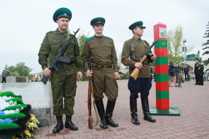 День пограничника. Солдаты в форме разных эпох стоят рядом с пограничным столбом.