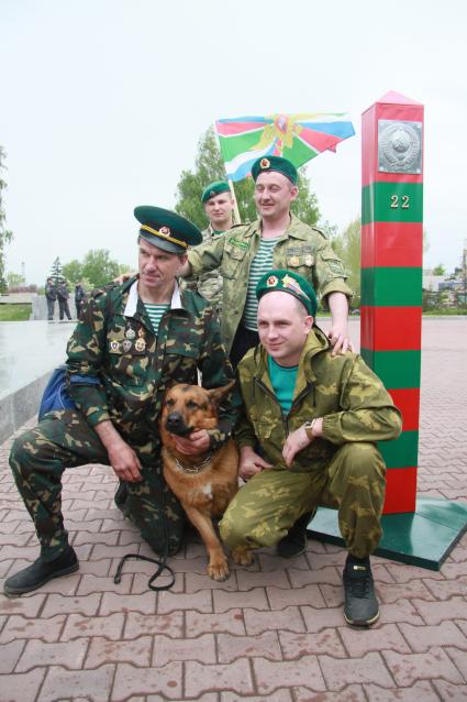 День пограничника. Мужчины позируют у пограничного столба.