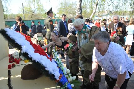 День Победы в деревне Вялки. На снимке: возложение цветов к памятной стелле с именами 67-ми погибших жителей деревни.