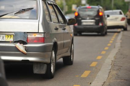 Автомобиль из багажника котогого видна нога.