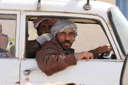 Египет. Эль-Саллум. На снимке: арабские мужчины едут в машине.