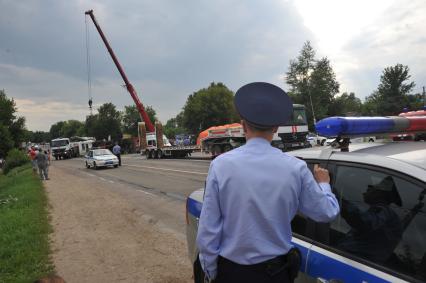 В результате ДТП под Подольском, погибли 18 пассажиров рейсового автобуса. Водитель КамАЗа не уступил дорогу автобусу и на полном ходу протаранил его. В результате удара груженного щебнем грузовика у автобуса оторвало заднюю часть. На снимке: место аварии.