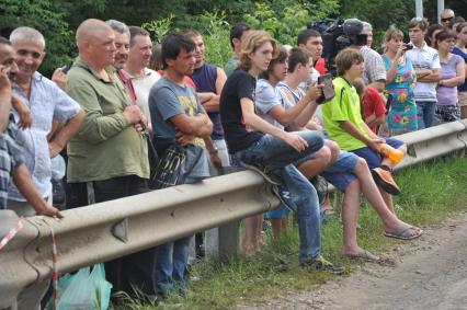 В результате ДТП под Подольском, погибли 18 пассажиров рейсового автобуса. Водитель КамАЗа не уступил дорогу автобусу и на полном ходу протаранил его. В результате удара груженного щебнем грузовика у автобуса оторвало заднюю часть. На снимке: зеваки.