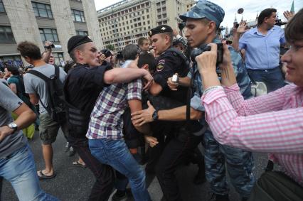 Несанкионированная акция в поддержку блогера, основателя антикоррупционного проекта `РосПил` Алексея Навального, обвиняемого в растрате имущества `Кировлеса` и приговоренного Ленинским судом г.Кирова к пяти годам лишения свободы. Митинг прошел на Манежной площади. На снимке: потасовка между активистом и полицейским на Тверской улице.