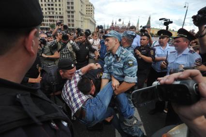 Несанкионированная акция в поддержку блогера, основателя антикоррупционного проекта `РосПил` Алексея Навального, обвиняемого в растрате имущества `Кировлеса` и приговоренного Ленинским судом г.Кирова к пяти годам лишения свободы. Митинг прошел на Манежной площади. На снимке: потасовка между активистом и полицейским на Тверской улице.