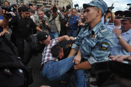 Несанкионированная акция в поддержку блогера, основателя антикоррупционного проекта `РосПил` Алексея Навального, обвиняемого в растрате имущества `Кировлеса` и приговоренного Ленинским судом г.Кирова к пяти годам лишения свободы. Митинг прошел на Манежной площади. На снимке: потасовка между активистом и полицейским на Тверской улице.